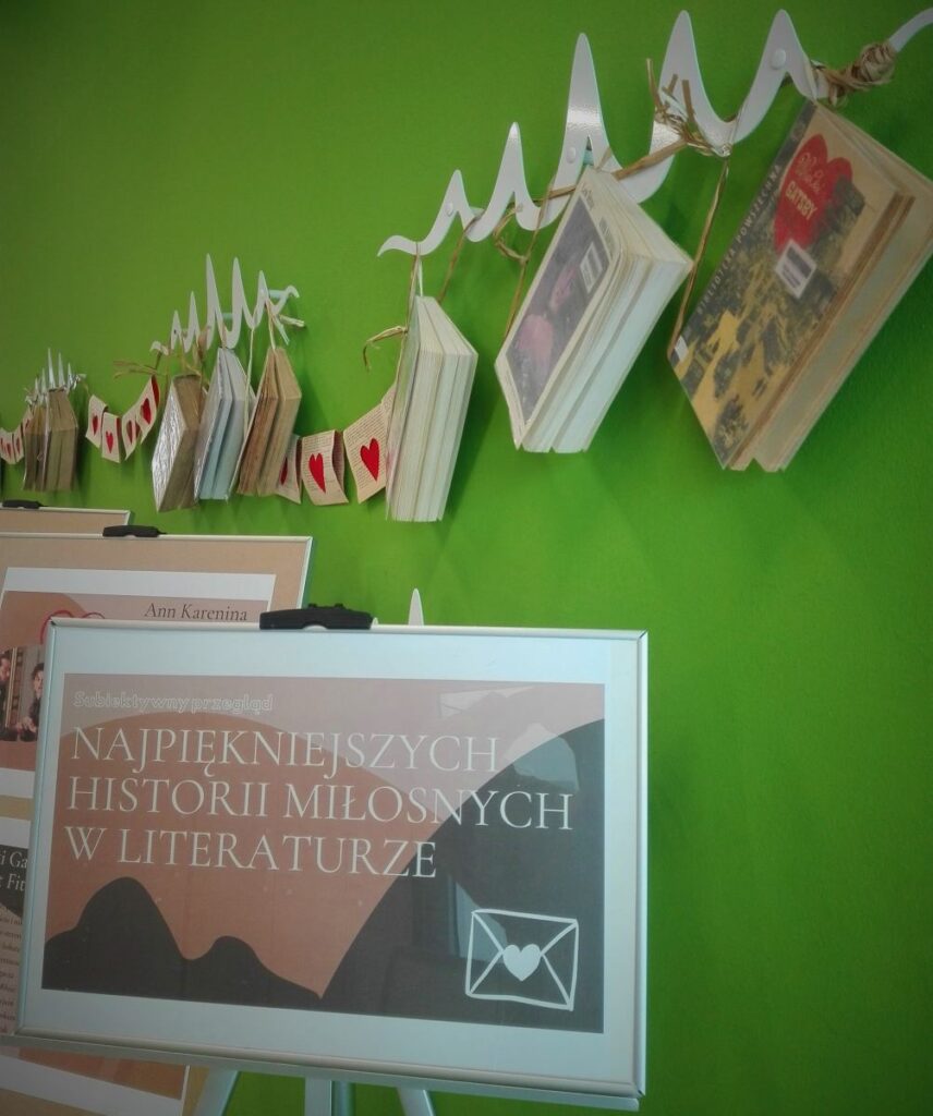 zdjęcie fotoram z plakatami ustawionymi na sztalugach i książek zawieszonych na ścianie