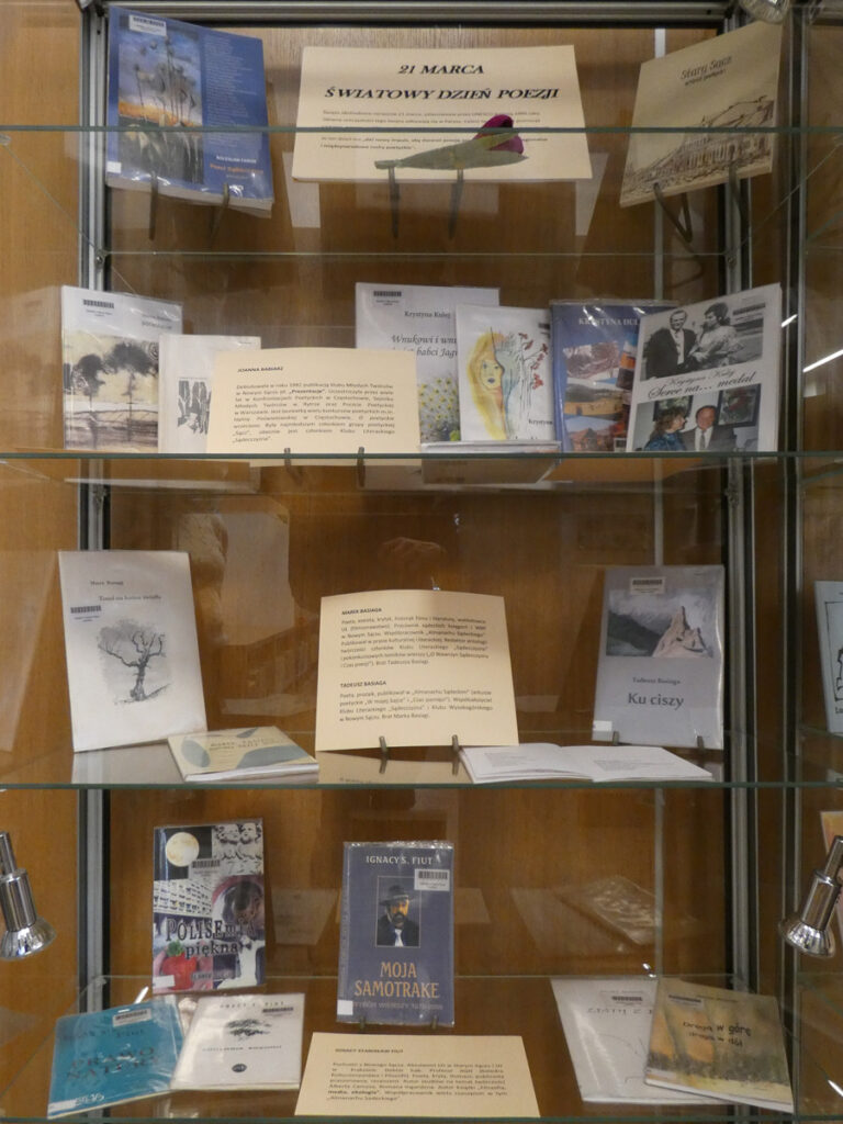 Szklana gablota z książkami i kartką informacyjną: "21 marca Światowy Dzień Poezji"